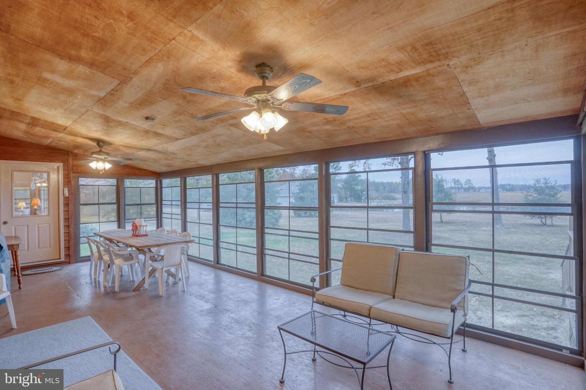 5 Bay Point Road Millsboro, DE 19966 - Photo 42 of 83 a living room with furniture a ceiling fan and a large window