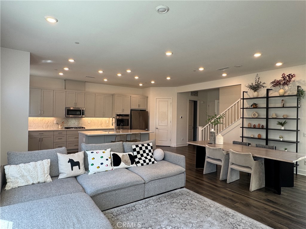 124 Yugen Irvine, CA 92618 - Photo 11 of 31 a living room with furniture a wooden floor and kitchen view