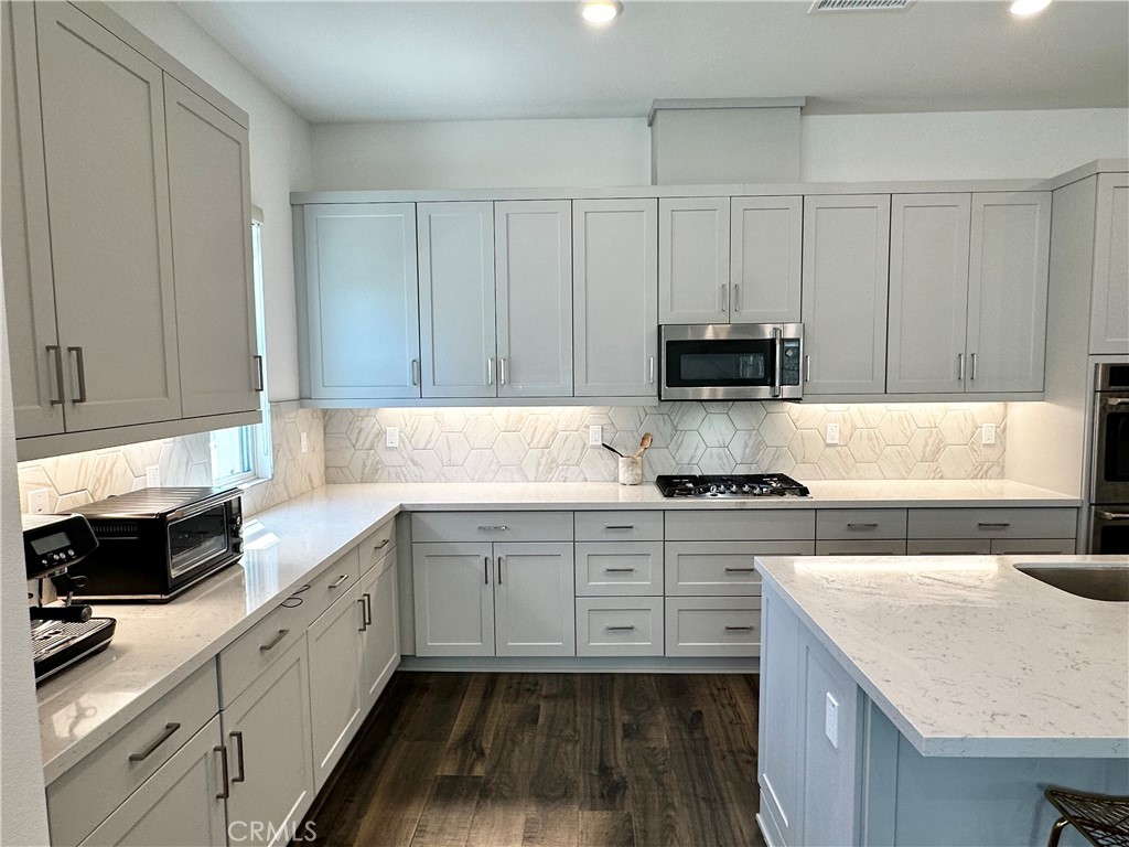 124 Yugen Irvine, CA 92618 - Photo 9 of 31 a kitchen with granite countertop white cabinets and white appliances