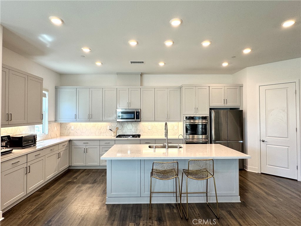 124 Yugen Irvine, CA 92618 - Photo 10 of 31 a kitchen with kitchen island a white counter top space cabinets and stainless steel appliances