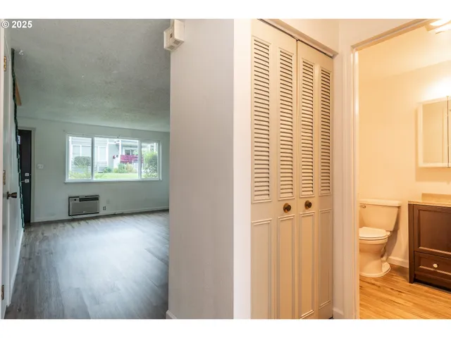 a view of a bathroom with a hardwood floor and a window