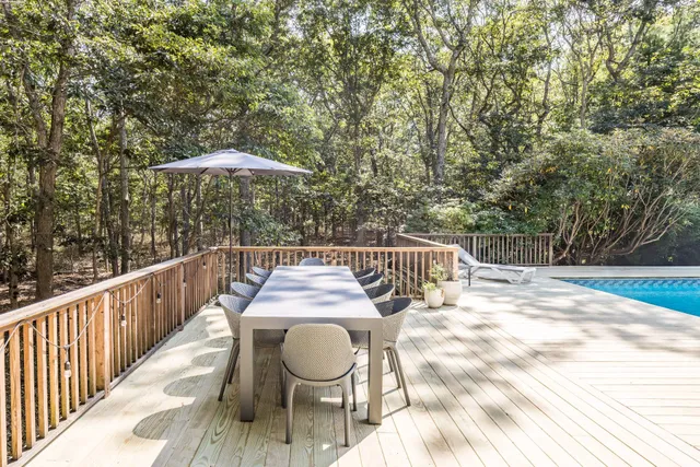 a balcony with wooden floor and outdoor seating