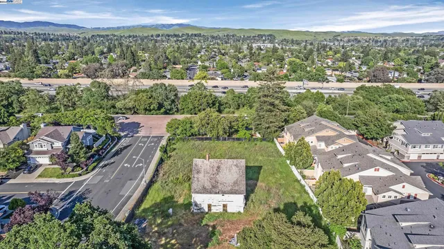 an aerial view of residential houses with outdoor space and trees