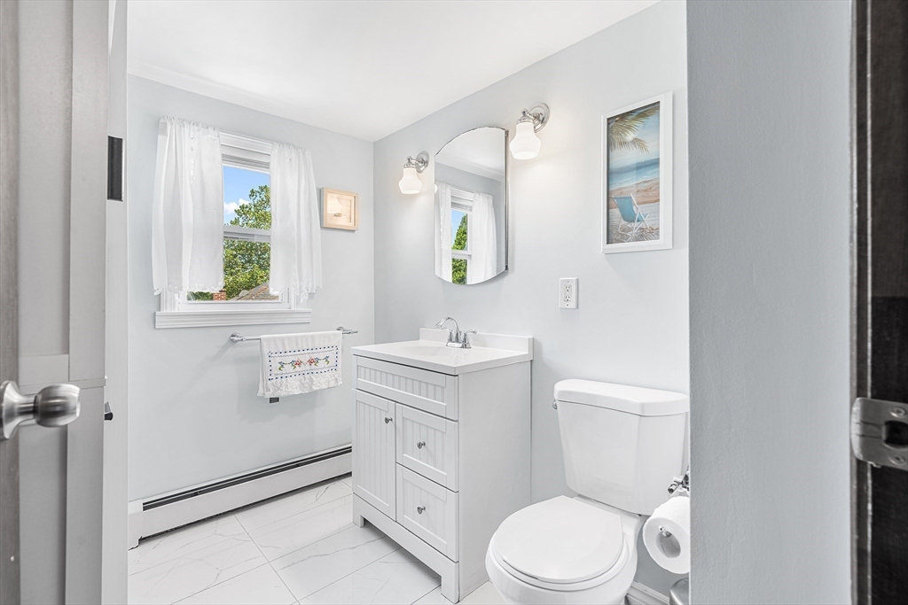 3 Fitz Road Peabody, MA 01960 - Photo 21 of 34 a bathroom with a toilet a sink a mirror a window and vanity