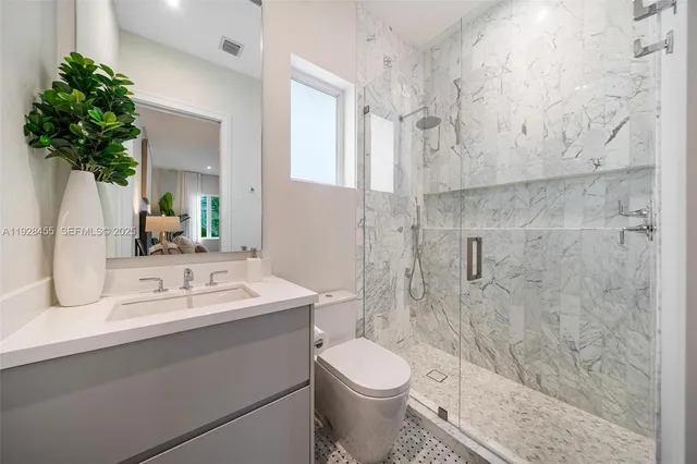 a view of a backyard with plants and large trees