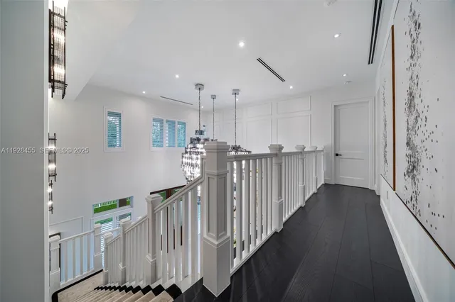 a view of a house with a small yard plants and large trees