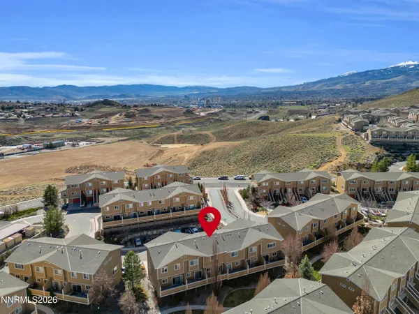 an aerial view of a house with a mountain