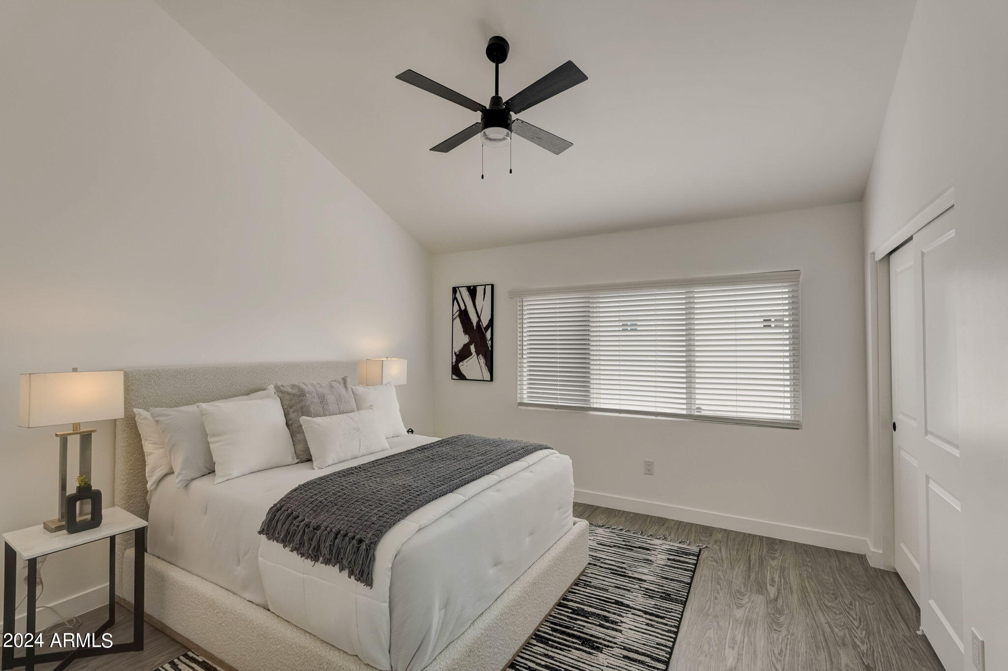 3645 East Earll Drive, Unit 15 Phoenix, AZ 85018 - Photo 11 of 27 a bedroom with a large bed chandelier and a window