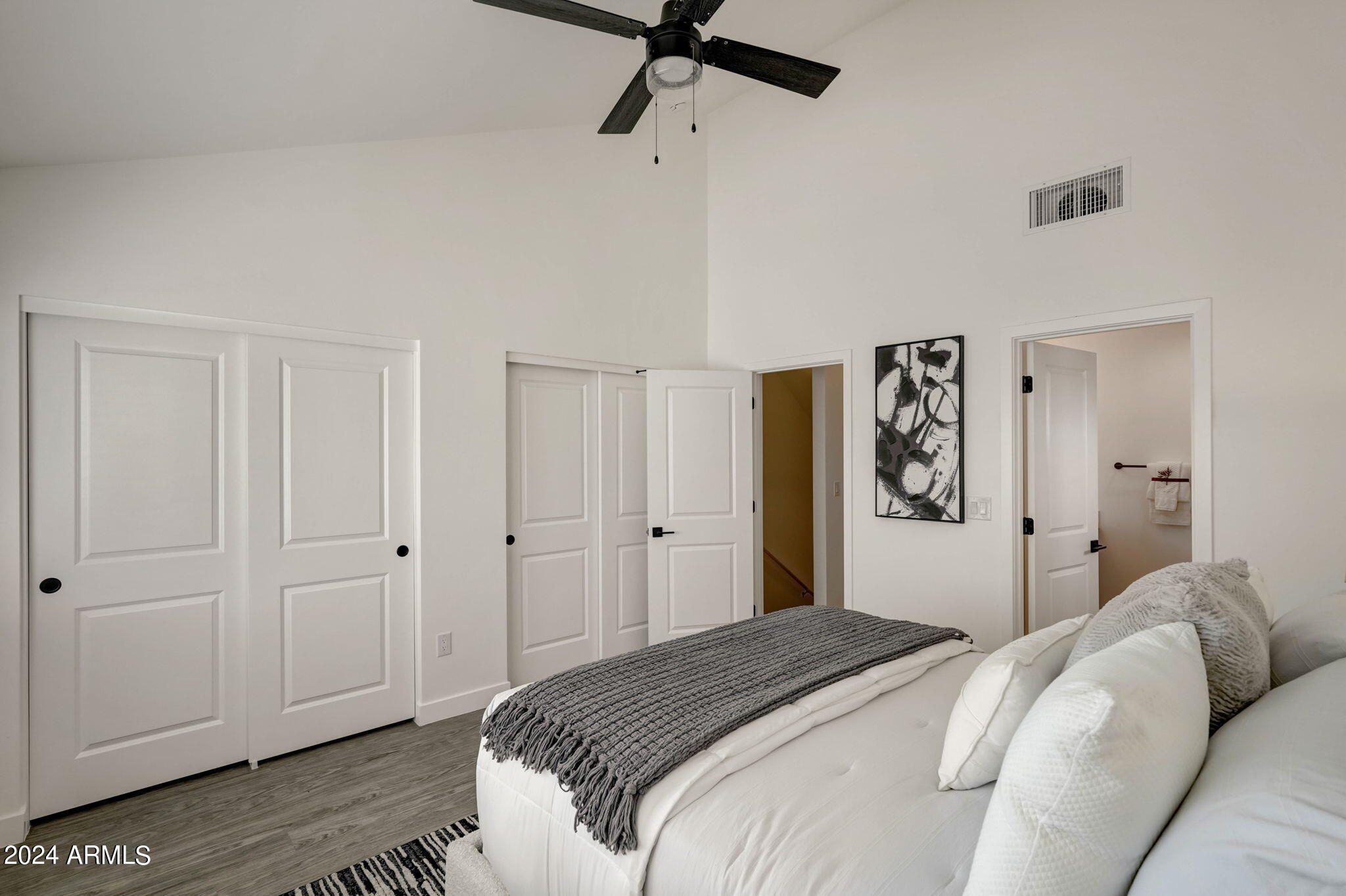 3645 East Earll Drive, Unit 15 Phoenix, AZ 85018 - Photo 12 of 27 a bedroom with a bed and a chandelier