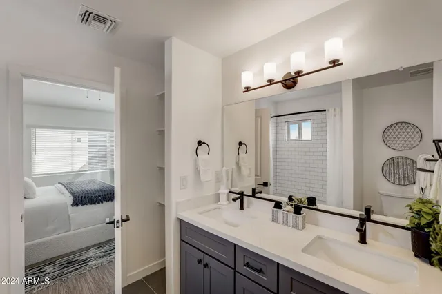 a bathroom with a double vanity sink a mirror and shower
