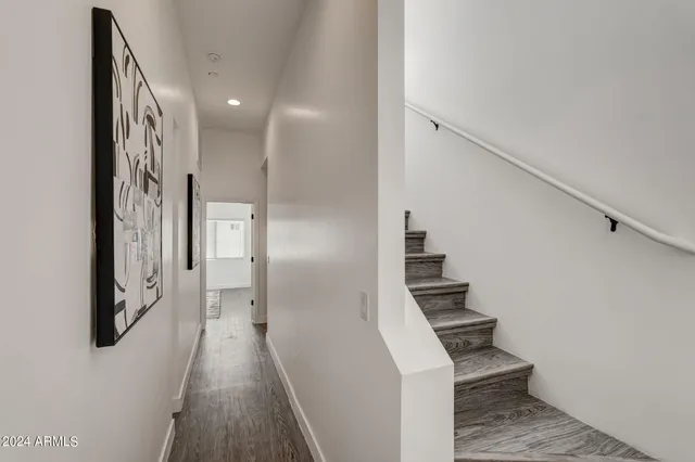 a view of hallway with stairs and wooden floor