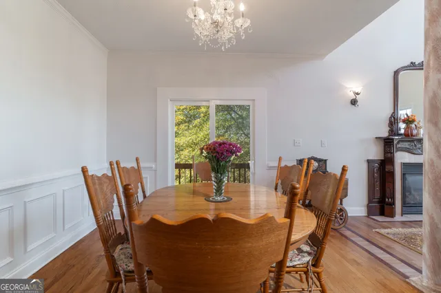 a dining room with furniture potted plants and wooden floor