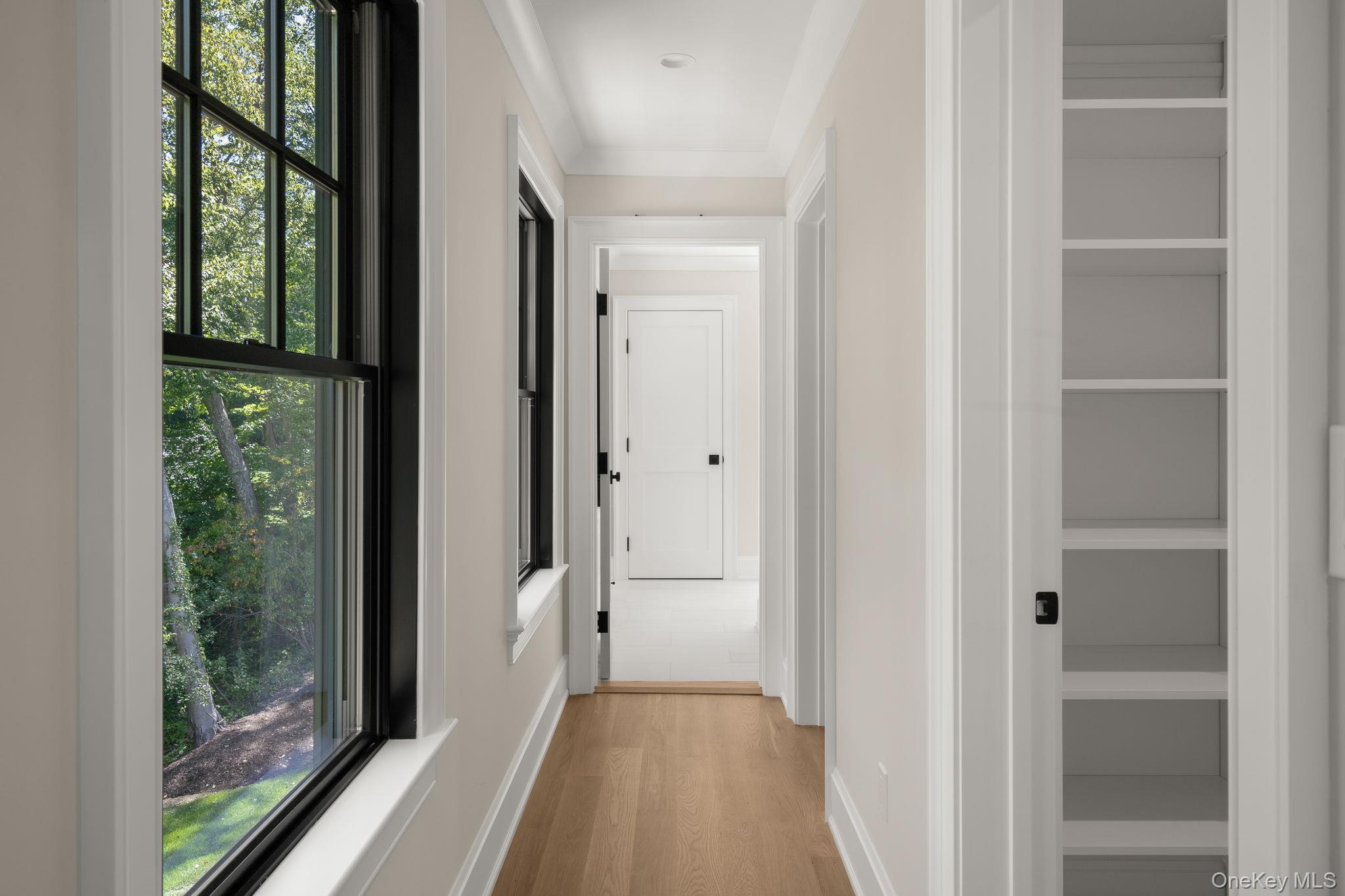 64 Saw Mill Road Cold Spring Harbor, NY 11724 - Photo 23 of 50 a view of a hallway with wooden floor and windows