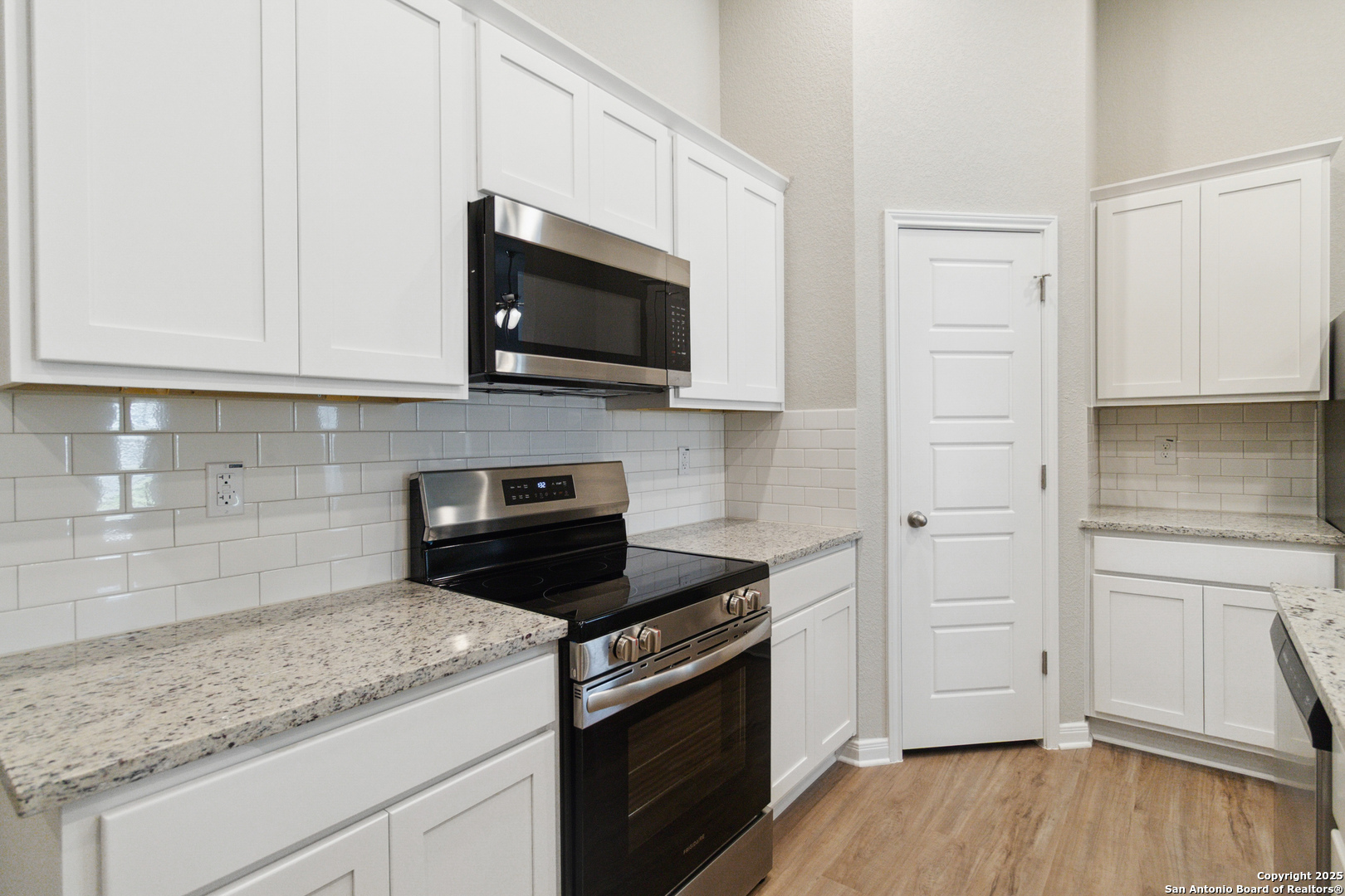 119 Gunner Road Buda, TX 78610 - Photo 14 of 30 a kitchen with white cabinets and black appliances