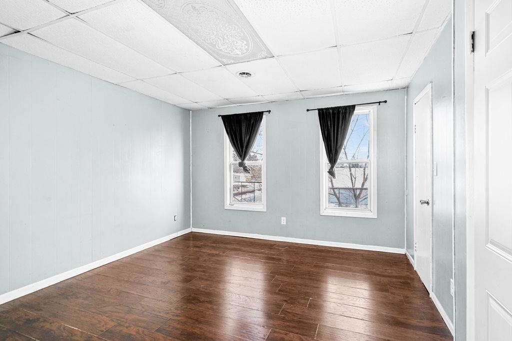605 Weeks Avenue Superior, WI 54880 - Photo 7 of 23 Spare room with a paneled ceiling and dark wood-style flooring
