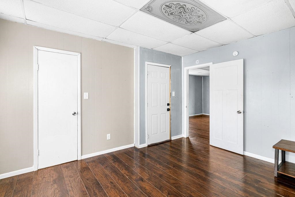 605 Weeks Avenue Superior, WI 54880 - Photo 8 of 23 Unfurnished bedroom with a paneled ceiling, dark wood finished floors, and wooden walls