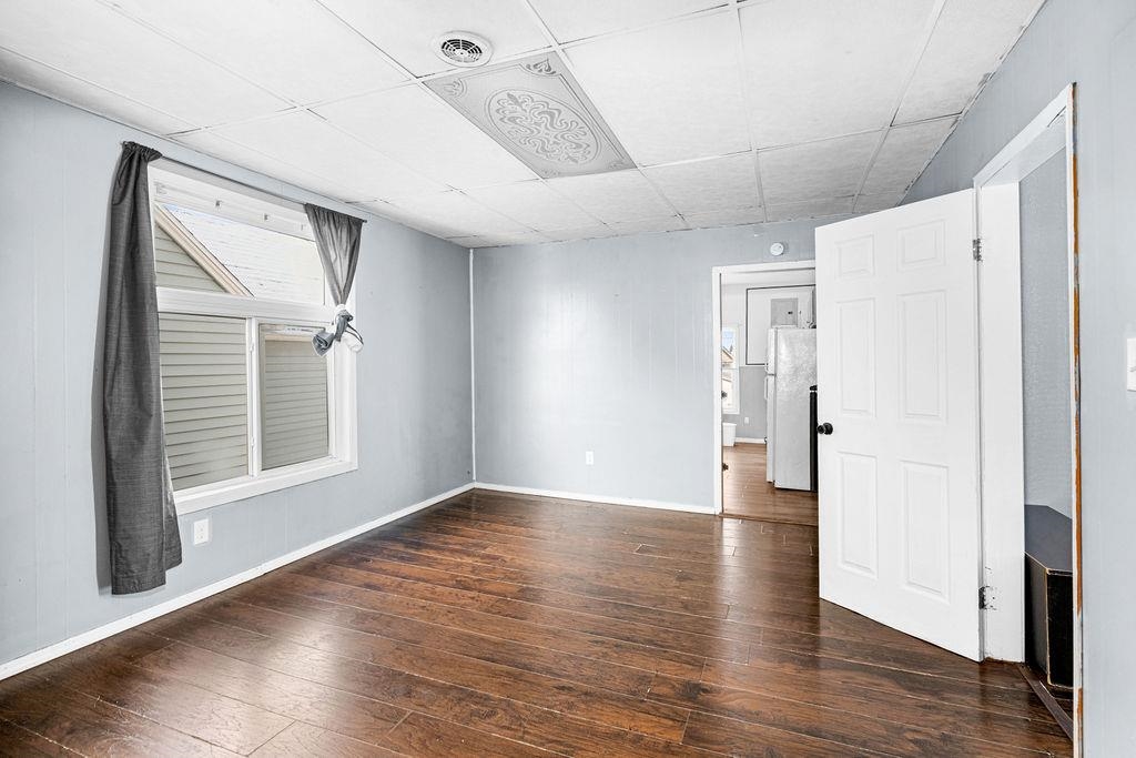 605 Weeks Avenue Superior, WI 54880 - Photo 9 of 23 Unfurnished room featuring a drop ceiling and dark wood-style flooring