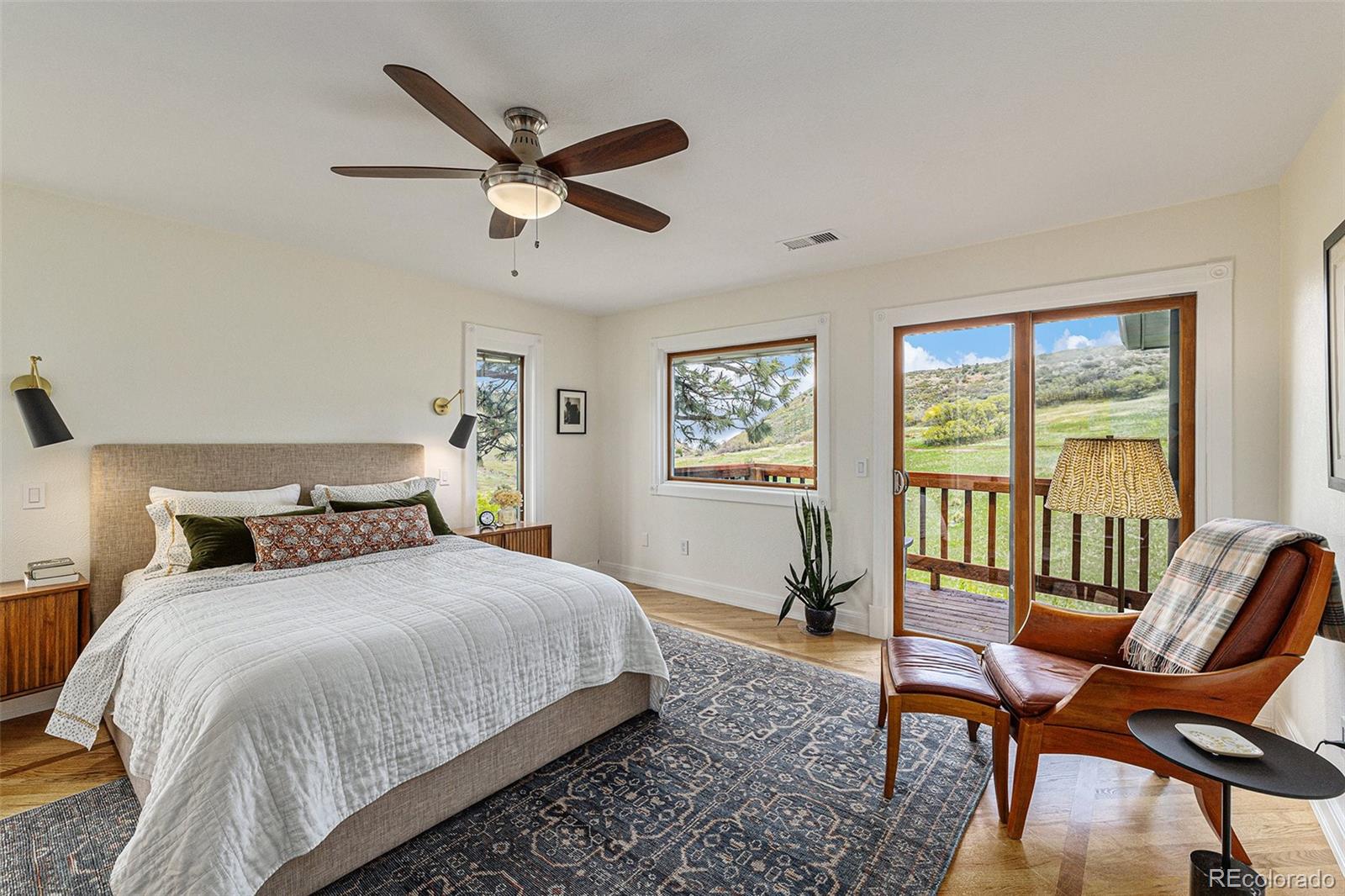 8 Blue Grouse Ridge Road Littleton, CO 80127 - Photo 21 of 49 a bedroom with a bed a large window and a chandelier