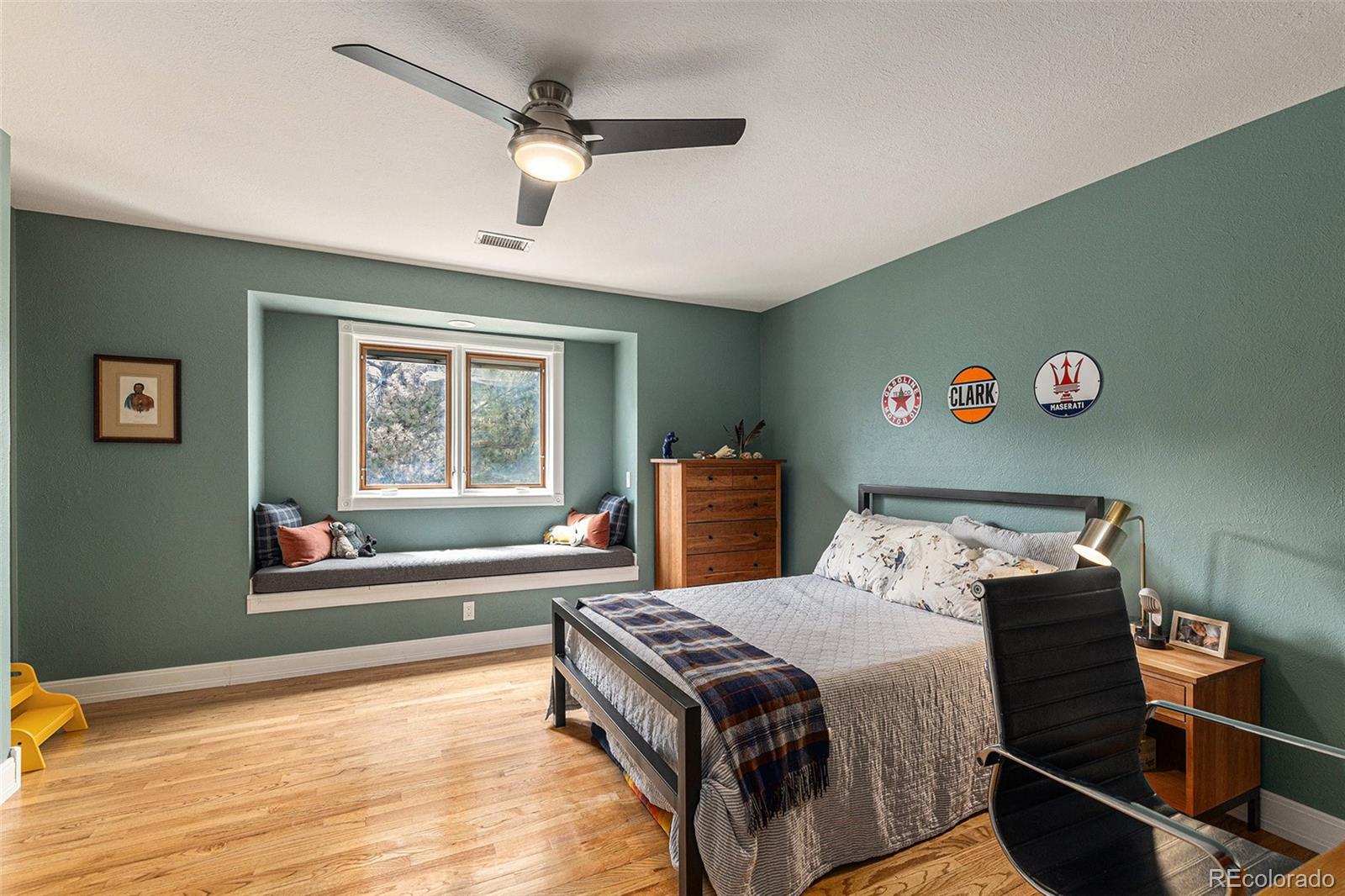 8 Blue Grouse Ridge Road Littleton, CO 80127 - Photo 25 of 49 a bedroom with a bed and a large window with wooden floor