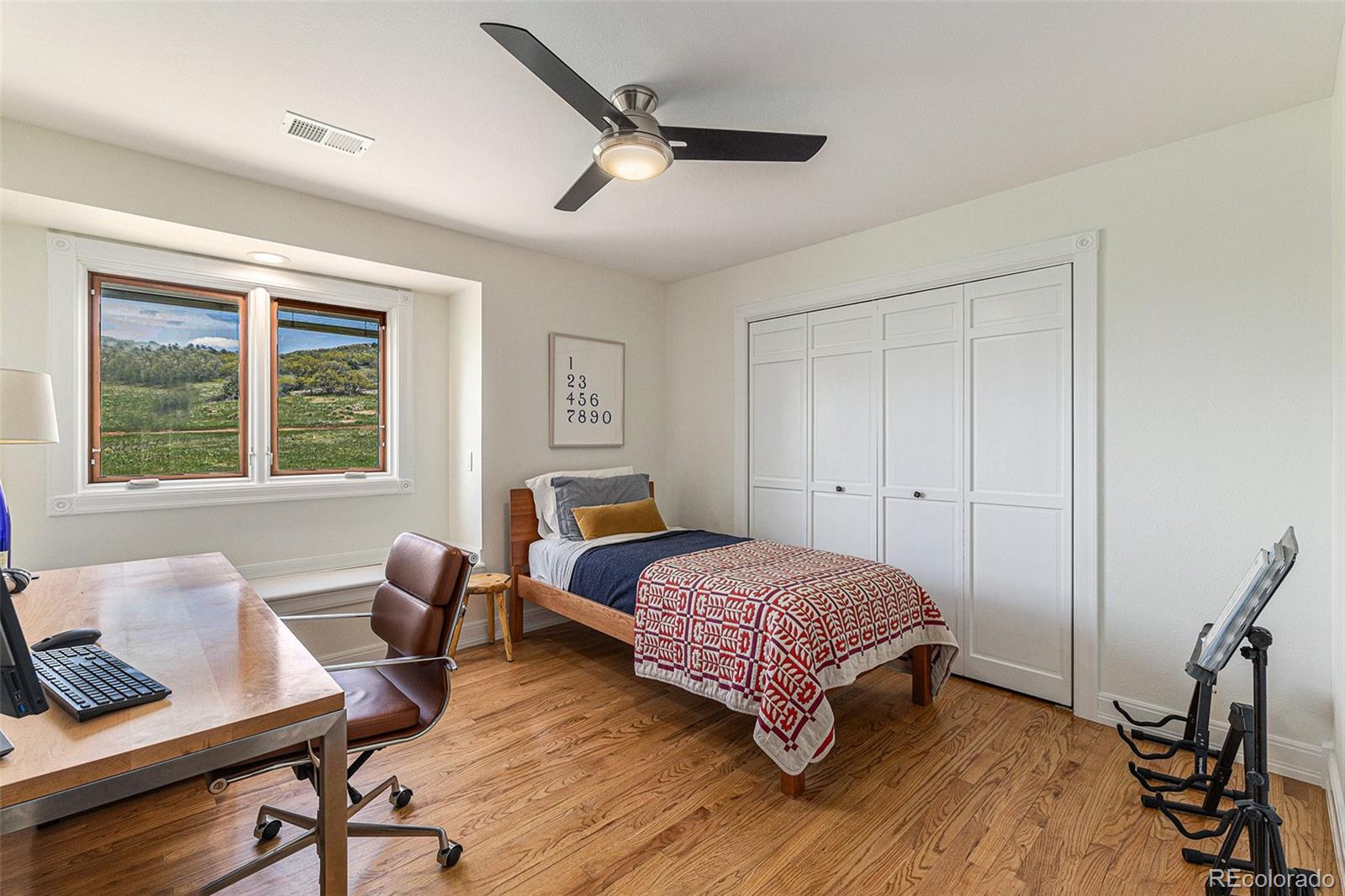 8 Blue Grouse Ridge Road Littleton, CO 80127 - Photo 27 of 49 a bedroom with a bed and wooden floor