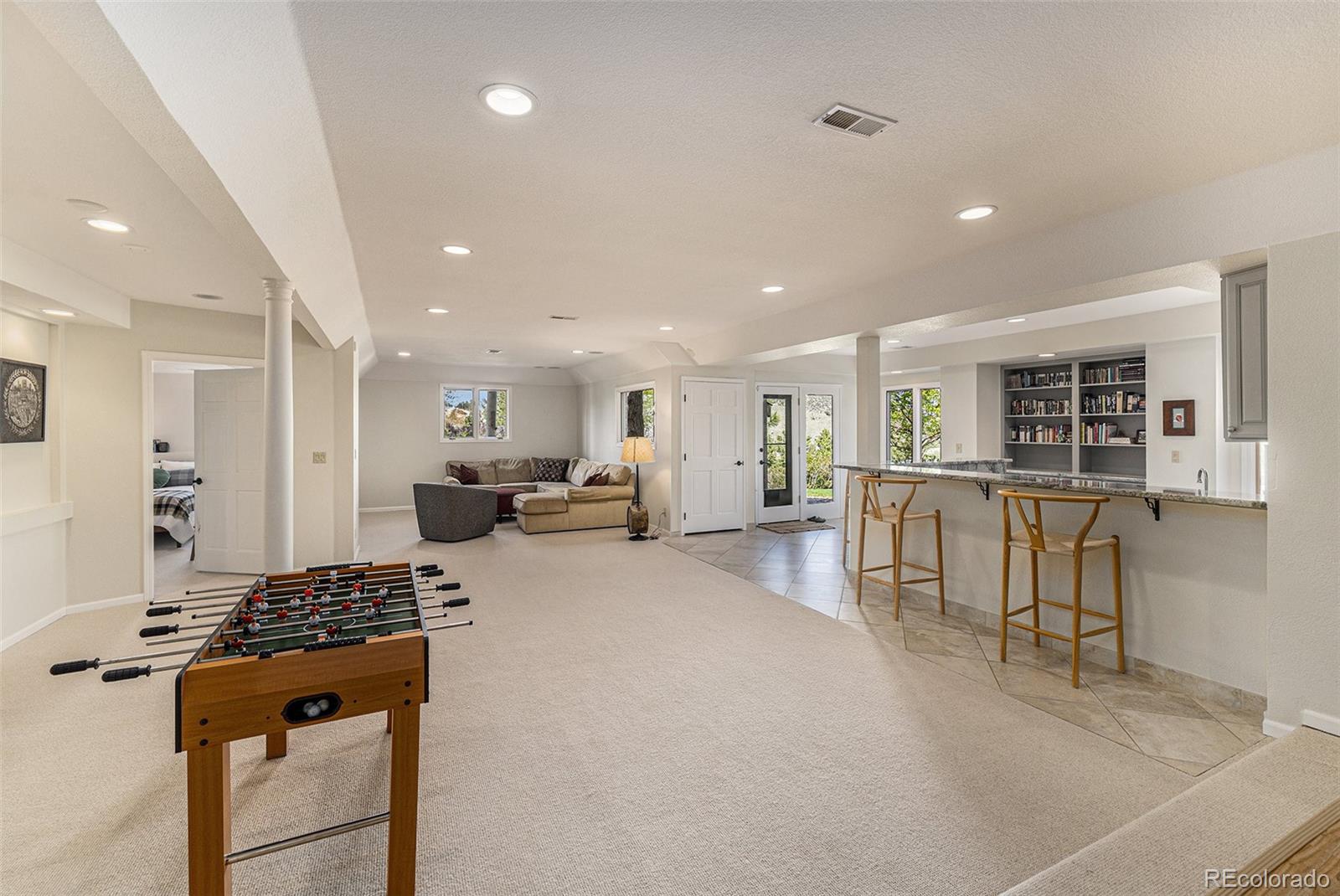 8 Blue Grouse Ridge Road Littleton, CO 80127 - Photo 30 of 49 a living room with furniture a table and kitchen view