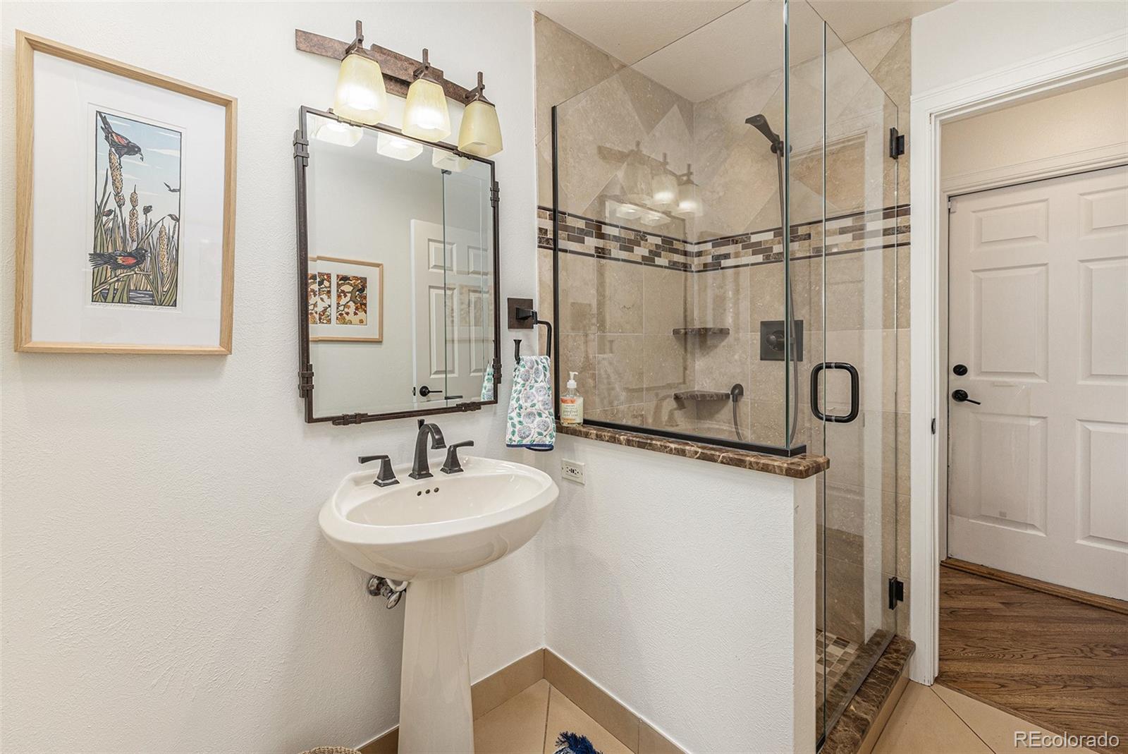 8 Blue Grouse Ridge Road Littleton, CO 80127 - Photo 40 of 49 a bathroom with a sink mirror and a shower