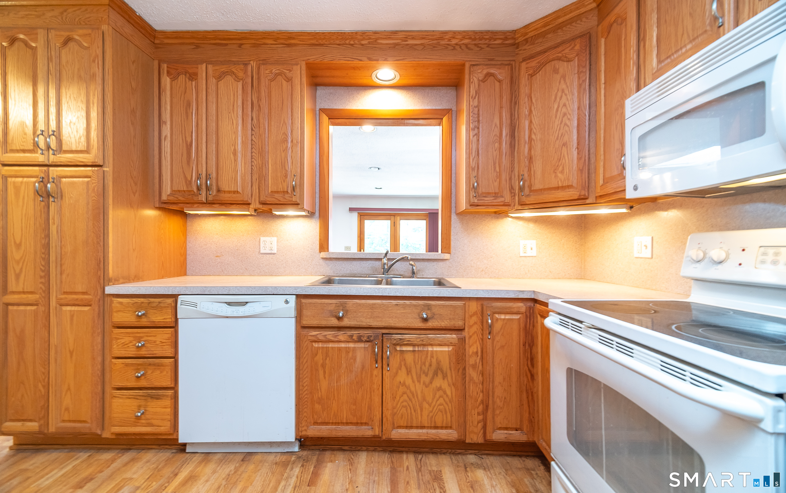127 Bee Street Meriden, CT 06450 - Photo 14 of 32 a kitchen with granite countertop wooden cabinets and white appliances