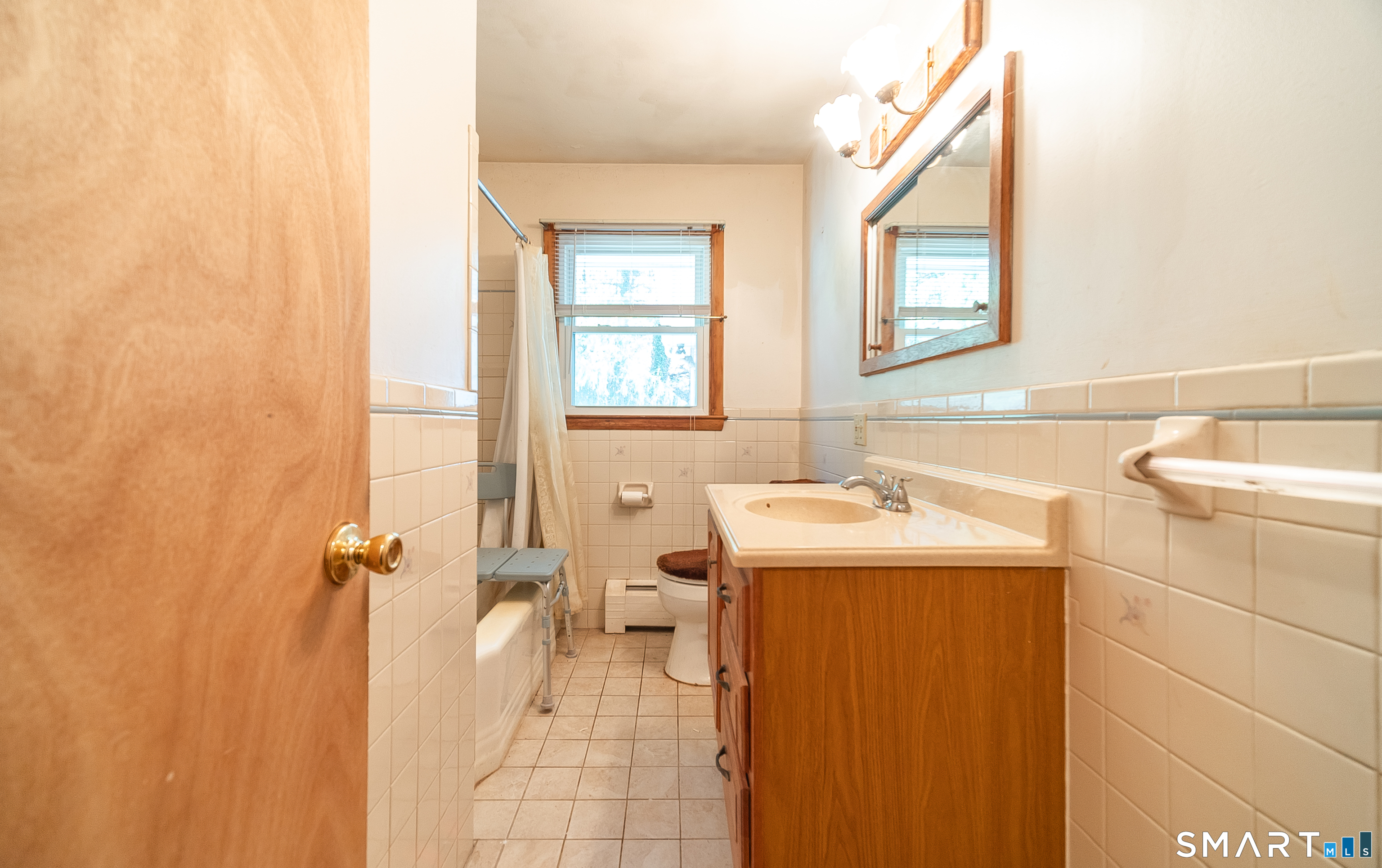 127 Bee Street Meriden, CT 06450 - Photo 21 of 32 a bathroom with a sink and mirror with toilet