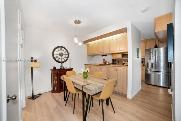 a view of a dining room with furniture a kitchen and chandelier