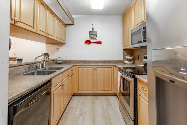 a kitchen with granite countertop a sink stove and cabinets