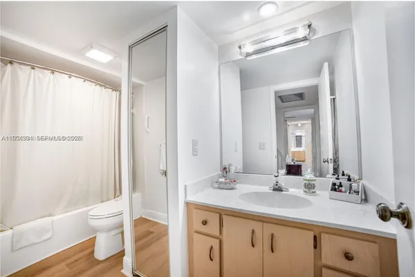 a bathroom with a granite countertop sink toilet a large mirror and shower