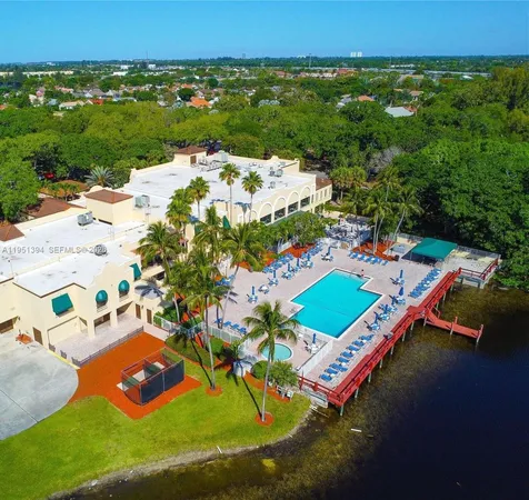 an aerial view of a house with a garden and lake view