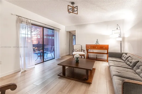 a living room with furniture a table and wooden floor