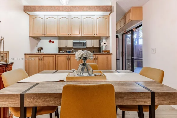 a kitchen with a table chairs sink and cabinets