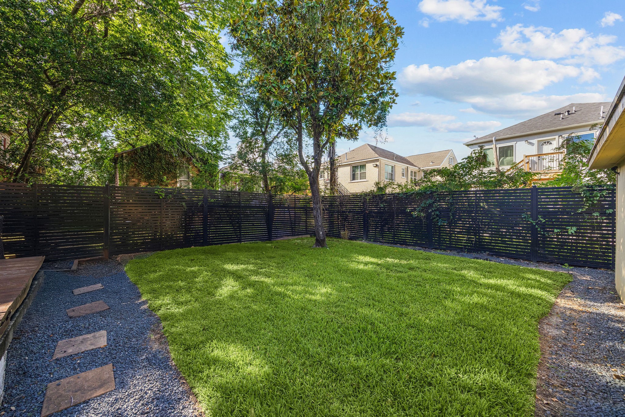 2613 Wichita Street Houston, TX 77004 - Photo 23 of 25 Spacious backyard with mature trees, lush green space, and plenty of room for pets, play, or outdoor gatherings.