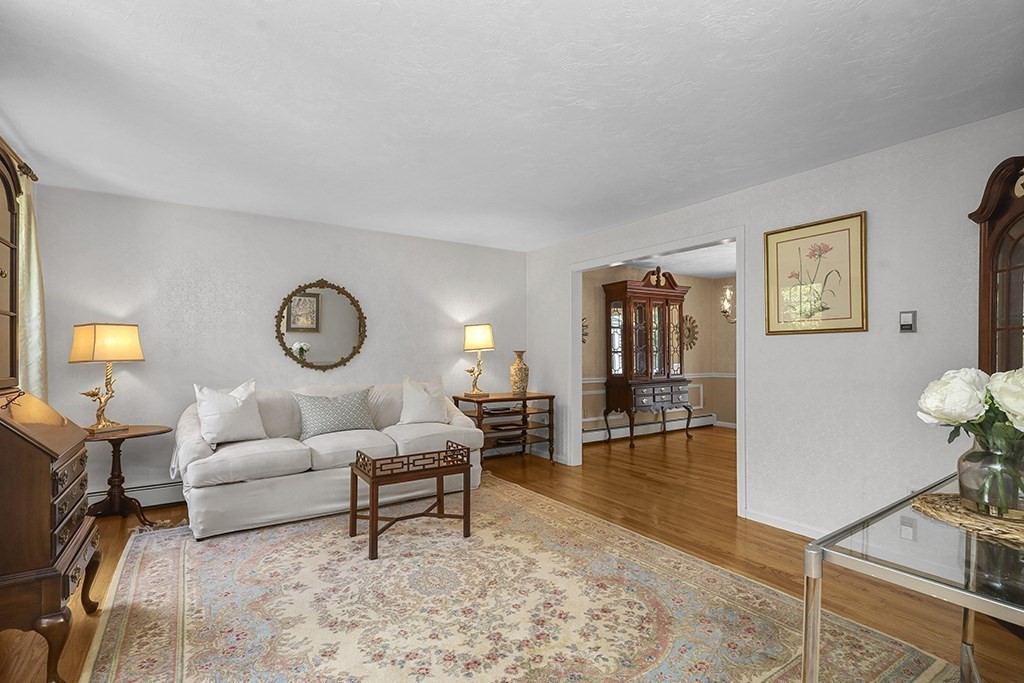 57 Vine Street North Attleboro, MA 02760 - Photo 12 of 41 a living room with furniture a dining table and paintings on the wall with wooden floor