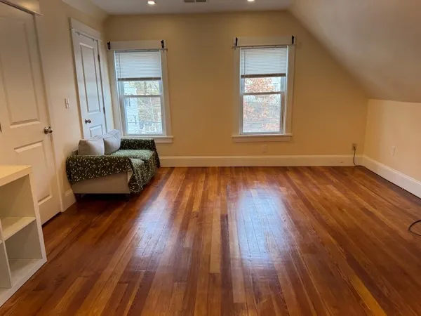 a living room with wooden floors and a window