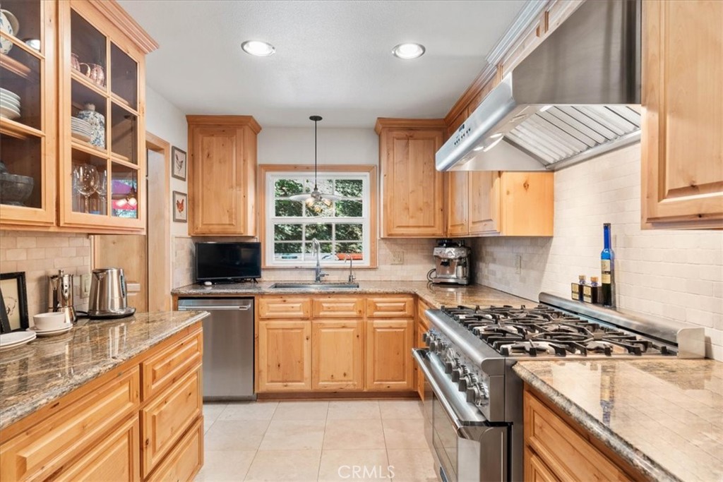 869 Mockingbird Road Wrightwood, CA 92397 - Photo 18 of 35 a kitchen with stainless steel appliances granite countertop a stove a sink and a microwave