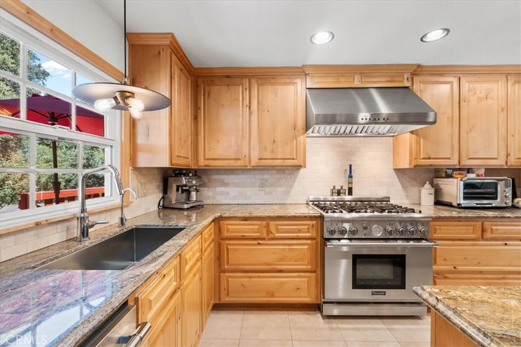 869 Mockingbird Road Wrightwood, CA 92397 - Photo 19 of 35 a kitchen with stainless steel appliances granite countertop a stove and a sink