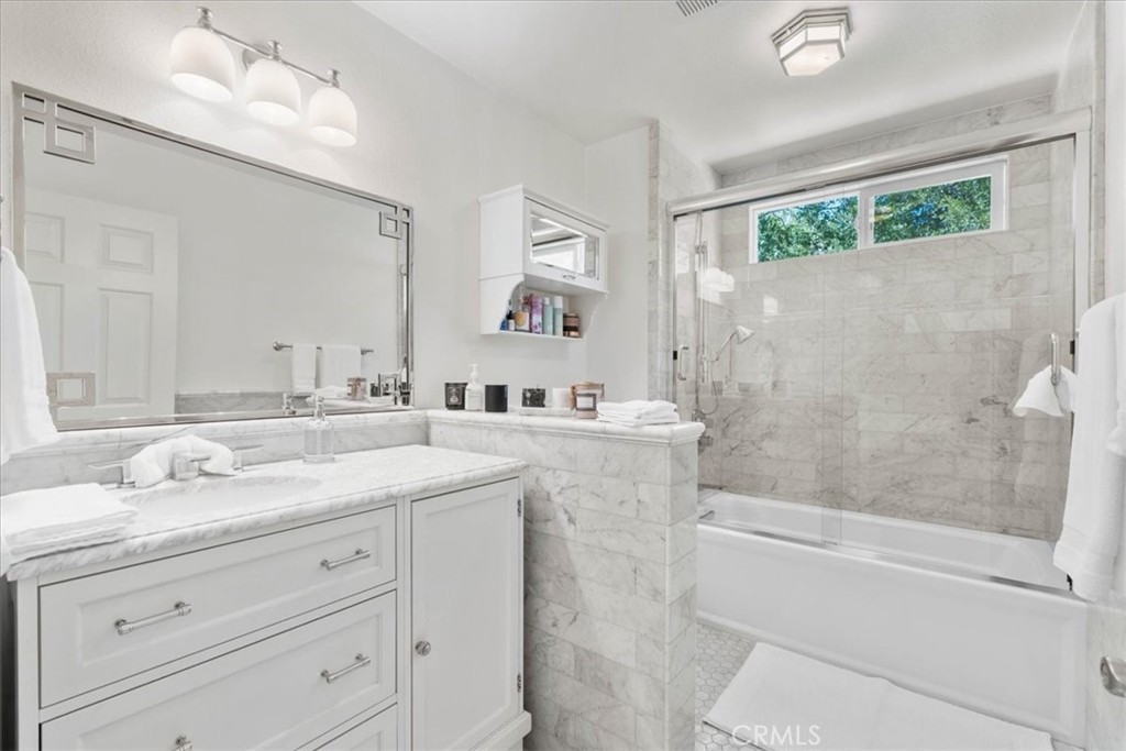 869 Mockingbird Road Wrightwood, CA 92397 - Photo 23 of 35 a bathroom with a granite countertop sink mirror vanity and bathtub
