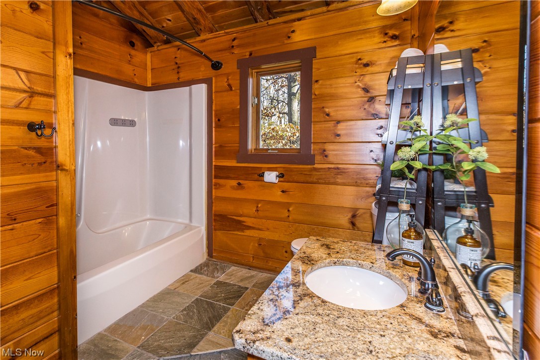 4069 Erhart Road Medina, OH 44256 - Photo 18 of 30 Bathroom featuring wood walls, bathing tub / shower combination, tile floors, wood ceiling, and beam ceiling