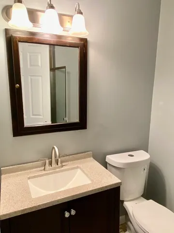 a bathroom with a sink a toilet and mirror