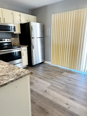 a kitchen with a refrigerator and a stove top oven