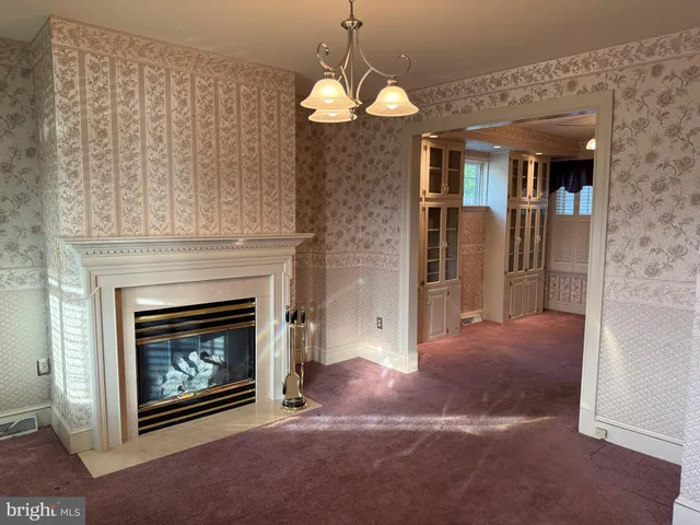 a view of a livingroom with a fireplace cabinet and window