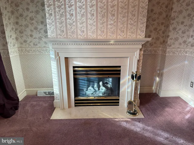 an empty room with windows and chandelier fan
