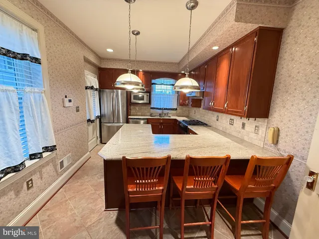a kitchen with stainless steel appliances granite countertop a sink a stove and a refrigerator