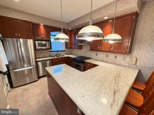 a kitchen with a sink a counter space and stainless steel appliances