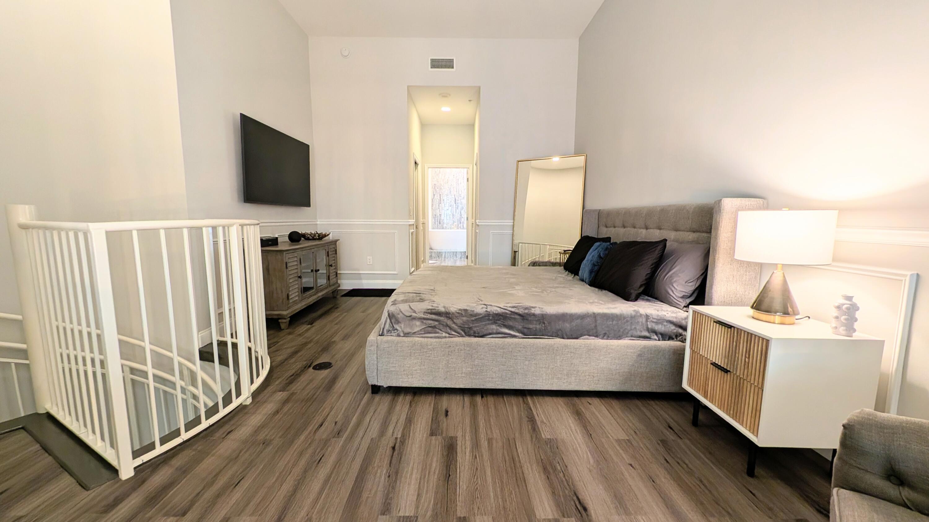 801 South Olive Avenue, Unit 435 West Palm Beach, FL 33401 - Photo 11 of 33 a spacious bedroom with a bed and a flat screen tv