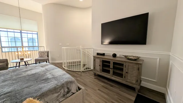 a spacious bedroom with a bed and a flat screen tv