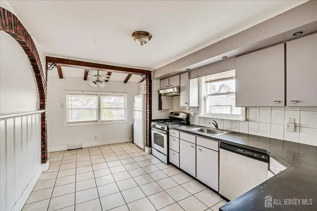 a kitchen with a sink a stove cabinets and a window